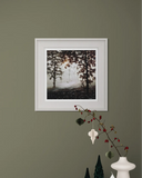 Framed artwork of trees on a wall with decorative elements below.