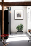 Modern interior with a plant, sean durkin art, and a red chair.