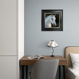 Framed picture of a horse on a wall above a desk with a lamp and chair.