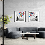 Modern living room with a gray sofa, white coffee table, and framed wall art on a brick wall.