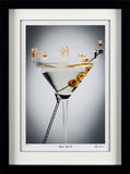 Framed artwork of a martini glass with olive spear, people figurines, and a black background.