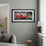 Framed picture of a red sports car on a gray wall in a living room.
