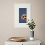 Framed photograph of a dog on a wall above a table with decorative items.