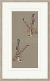 Framed artwork of two hares on a beige background