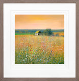 Framed artwork of a barn in a field with a colorful sky.