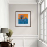 Framed artwork on a wall in a room with a window and desk.