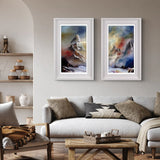Living room with two framed mountain paintings above a sofa.
