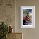 Framed mountain landscape painting on a wall with decorative elements