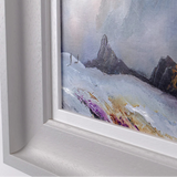 Framed painting of a mountain landscape with a gray frame.