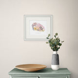 framed artwork on wall above green side board.