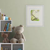 Children's room with teddy bear, books, and framed artwork on a green wall.