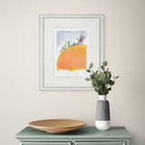 Framed abstract art piece on a wall above a table with a vase and plate.