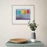 Framed artwork on a wall above a table with decorative items.
