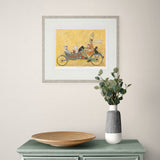 Framed artwork on a wall above a table with a vase and plate.