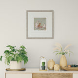 Decorative setup with plants, vases, and a framed picture on a wall.