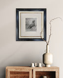 framed sketch of horse rearing on it's hind legs on a wall above a wooden side board.
