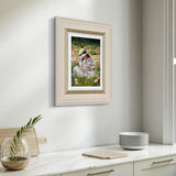 Framed artwork of a young girl in a field hanging on a wall above a kitchen counter.