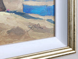 Close-up of a painting with a signature in a gold frame