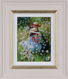 Framed artwork of two girls sitting in a field of flowers with a gold frame.