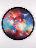 Round wall art piece with a colorful cloud design on a white background