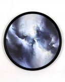 Round wall art piece with a black frame featuring a cosmic scene.