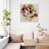 Living room with a floral painting on the wall, beige sofa, and decorative plants.