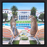 Two cheetahs sitting on lounge chairs by a pool with a luxurious villa in the background.