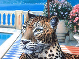 Leopard sitting by a pool with flowers and a fence in the background