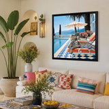 Living room with a couch, decorative pillows, and a framed picture of a poolside scene.