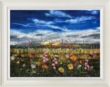 summer meadow of yellow, pink and orange florals against blue sky.