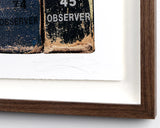 Close-up of a framed artwork with text '74 OBSERVER' and '45 OBSERVER' on a white background.