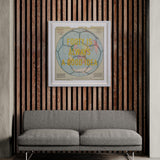 Framed artwork with text on a wall above a gray sofa.