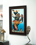 Framed artwork of a group of people on a wall with decorative items.