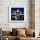 Framed cityscape artwork on a brick wall above a brown sofa with pillows.