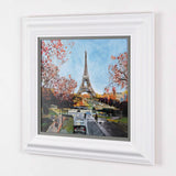 sideview of cityscape artwork of eiffel tower surrounded by red trees framed in white on plain white wall