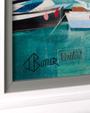 Close-up of a framed artwork showing painted boats on turquoise water, with part of a white frame visible and the words 'TButler Voila!' on the painting.