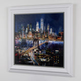 side view of textured collage artwork of skyline at night on plain white wall