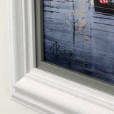 Framed artwork with a white frame and visible brand logo.