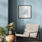 Modern chair with potted plants against a blue wall with a framed picture.