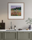 Framed artwork of a field with flowers and animals above a kitchen counter.