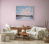 A framed landscape painting of a pink and blue sunset over water