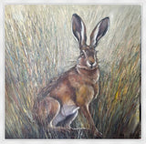 A painted artwork of a brown hare sitting in tall grass, with a white frame around the artwork.