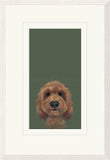 Framed art print featuring a painted portrait of a brown curly-haired dog on a muted olive green background, shown with a wide white mat and light wood frame.
