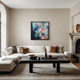 A framed floral painting in blue and red hangs in a modern living room setting.